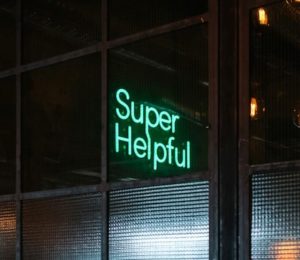 Neon green sign that says "super helpful."