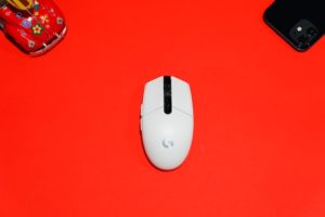 White computer mouse against a red backdrop.