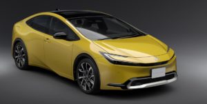 Redesigned yellow Toyota Prius against a gray backdrop.