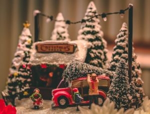 Toy display of family tying a Christmas tree to the top of a car.