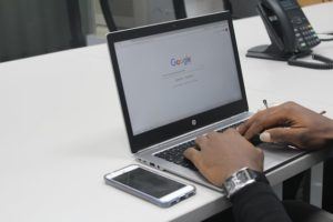 Man typing a question into Google Search.